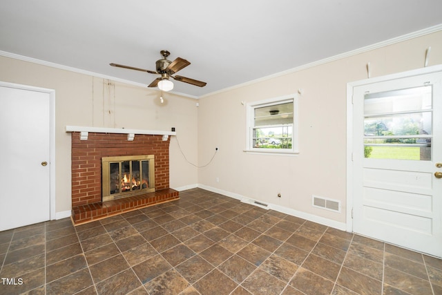 unfurnished living room with ceiling fan, visible vents, a brick fireplace, baseboards, and ornamental molding