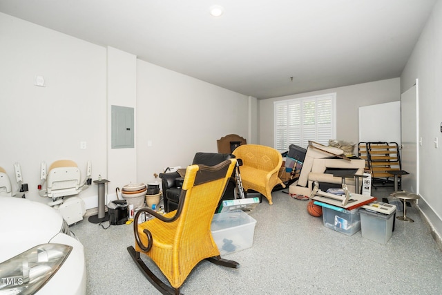living area featuring speckled floor and electric panel