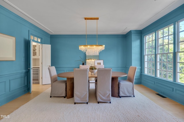 dining room with crown molding, visible vents, plenty of natural light, and wood finished floors