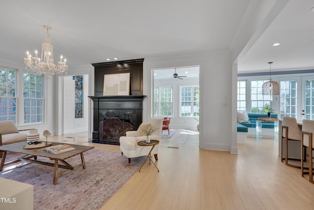 living room with baseboards, ornamental molding, light wood-style floors, and a fireplace