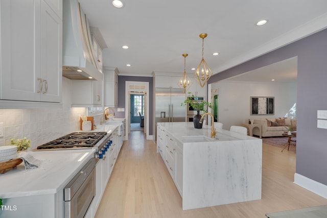 kitchen featuring crown molding, light wood-type flooring, custom exhaust hood, stainless steel appliances, and recessed lighting