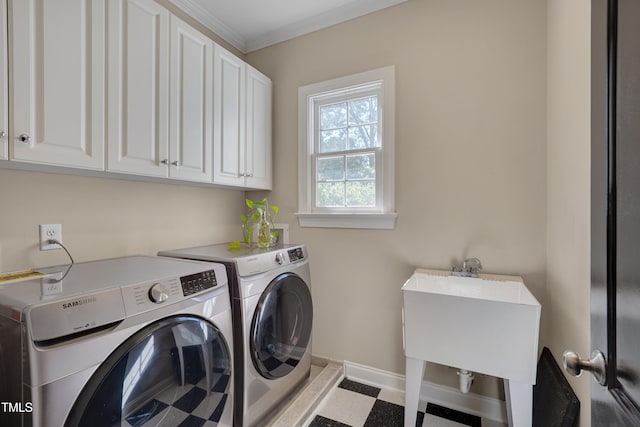 washroom featuring baseboards, ornamental molding, cabinet space, and washing machine and clothes dryer