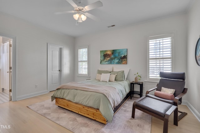 bedroom with visible vents, light wood finished floors, baseboards, and multiple windows