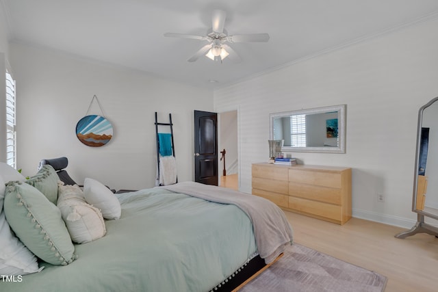 bedroom featuring baseboards, ornamental molding, a ceiling fan, and light wood-style flooring