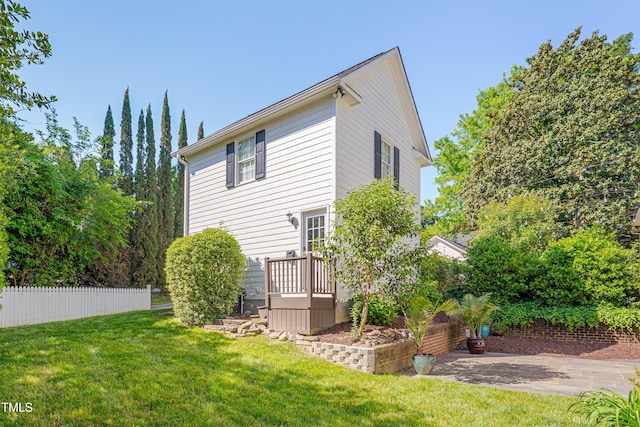 rear view of house with fence and a yard