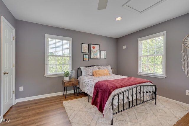 bedroom with recessed lighting, baseboards, multiple windows, and wood finished floors
