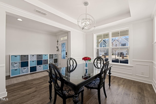 6633 Penfield St, Wake Forest, NC 27587 - dining room with a chandelier, healthy amount of natural light, dark wood finished floors, a raised ceiling, and wainscoting