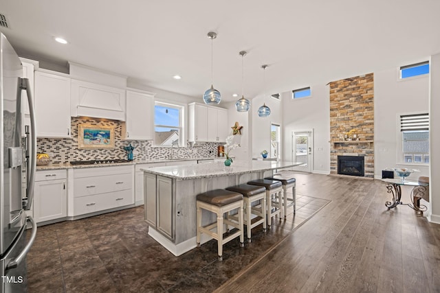 6633 Penfield St, Wake Forest, NC 27587 - kitchen with stainless steel appliances, open floor plan, a kitchen island, white cabinets, and recessed lighting