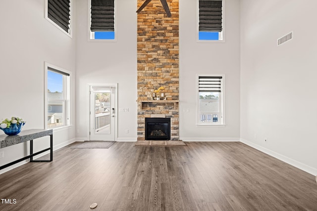 6633 Penfield St, Wake Forest, NC 27587 - unfurnished living room featuring a high ceiling, wood finished floors, a fireplace, and baseboards