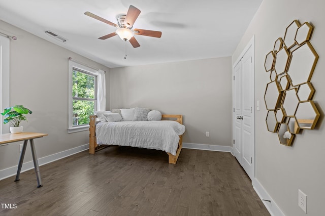 bedroom featuring visible vents, dark wood-style flooring, and baseboards