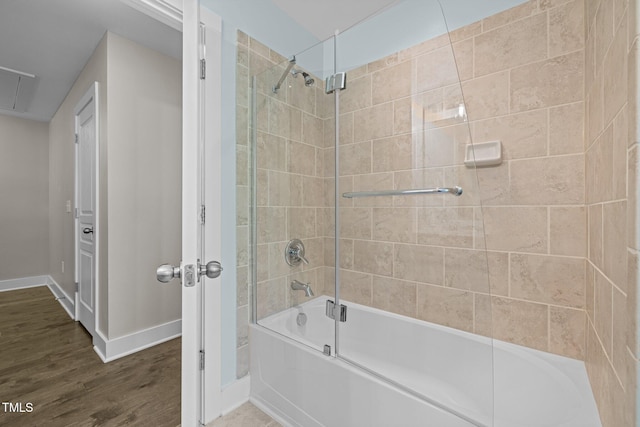 bathroom with baseboards, enclosed tub / shower combo, and wood finished floors