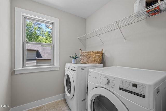 washroom with laundry area, washing machine and dryer, and baseboards