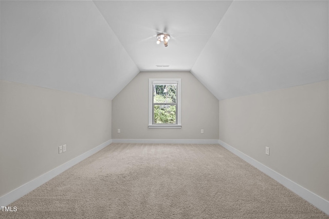 bonus room featuring carpet floors, baseboards, visible vents, and lofted ceiling