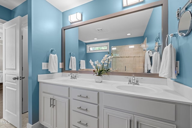 full bathroom with a sink, double vanity, tiled shower, and visible vents