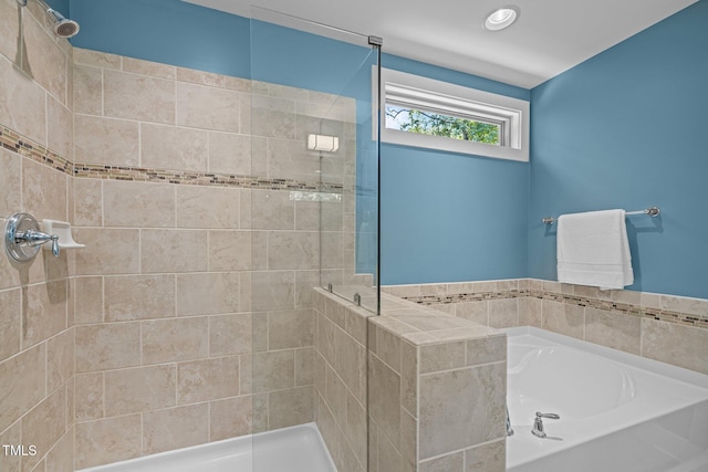 bathroom featuring recessed lighting, a bath, and a stall shower