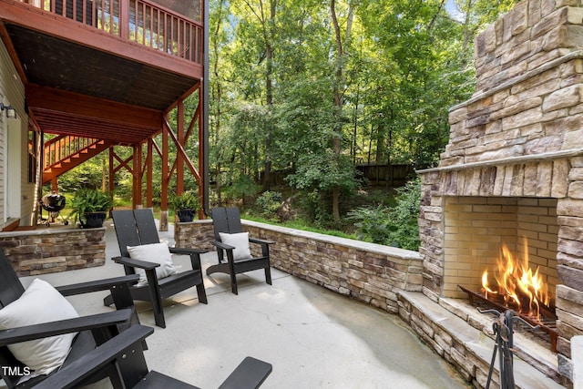 view of patio / terrace with stairway, an outdoor stone fireplace, and a fenced backyard