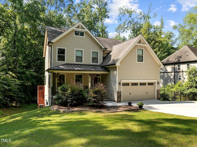 view of front of property featuring covered porch, a standing seam roof, a front yard, concrete driveway, and an attached garage