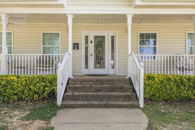 view of exterior entry featuring covered porch