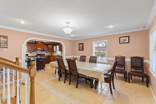 dining space with arched walkways, a textured ceiling, plenty of natural light, and light tile patterned flooring