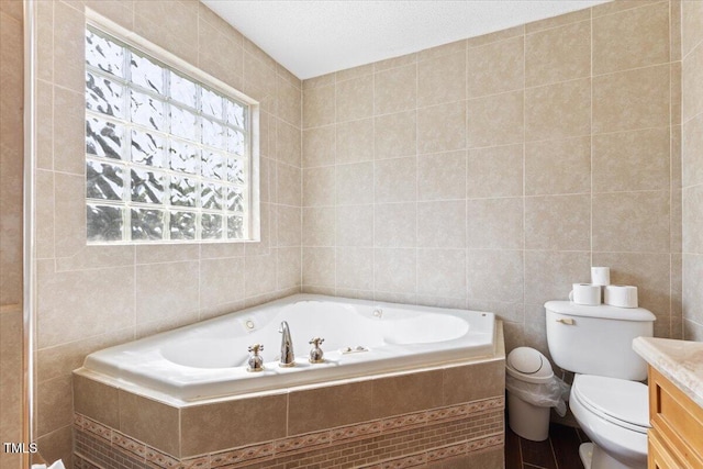 bathroom featuring vanity, tile walls, a garden tub, and toilet