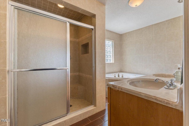bathroom featuring a garden tub, a sink, tile walls, and a shower stall