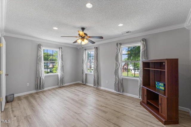 spare room featuring crown molding, visible vents, wood finished floors, ceiling fan, and a textured ceiling