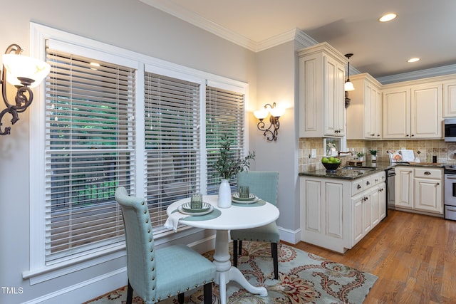 kitchen featuring decorative backsplash, dishwasher, light wood finished floors, ornamental molding, and recessed lighting