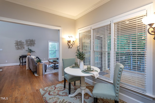 dining room with crown molding, baseboards, and wood finished floors