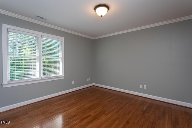 unfurnished room with visible vents, crown molding, baseboards, and dark wood-type flooring