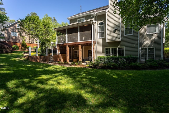 rear view of property with a yard, a sunroom, and brick siding