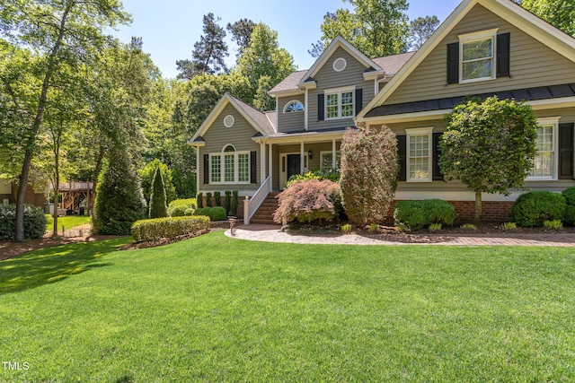 craftsman inspired home with roof with shingles, a front lawn, a standing seam roof, covered porch, and metal roof