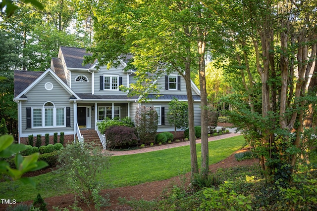 view of front of home with stairs, a shingled roof, a porch, and a front lawn