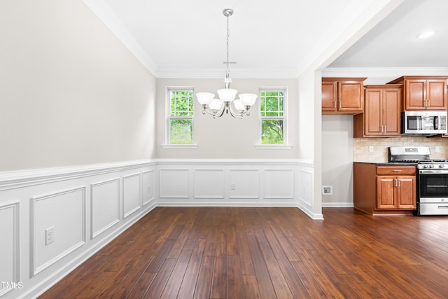 kitchen with crown molding, a chandelier, brown cabinetry, dark wood finished floors, and stainless steel appliances