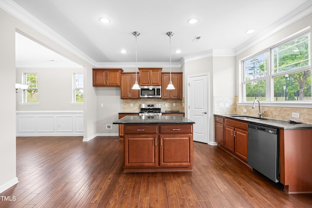 kitchen with brown cabinets, a sink, dark wood-style floors, ornamental molding, and stainless steel appliances