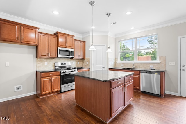 kitchen with brown cabinetry, crown molding, a sink, and appliances with stainless steel finishes