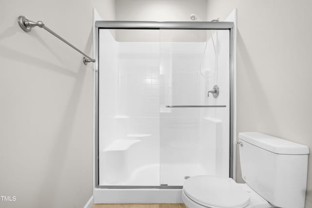 full bath featuring toilet and a stall shower