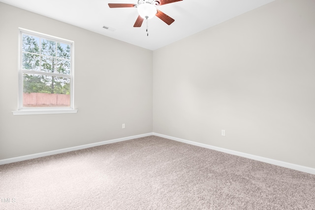 carpeted spare room with ceiling fan, visible vents, and baseboards