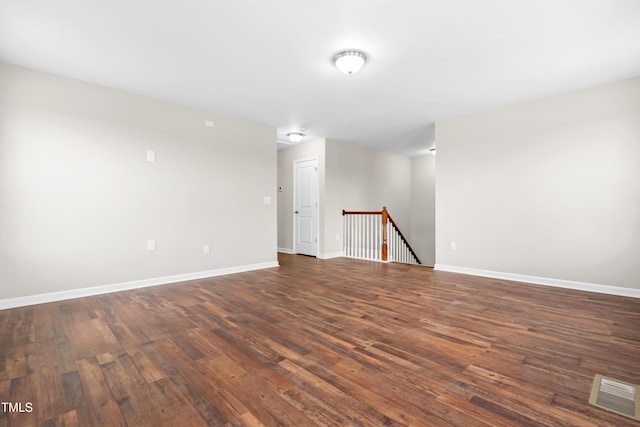 interior space featuring baseboards, dark wood-type flooring, and visible vents