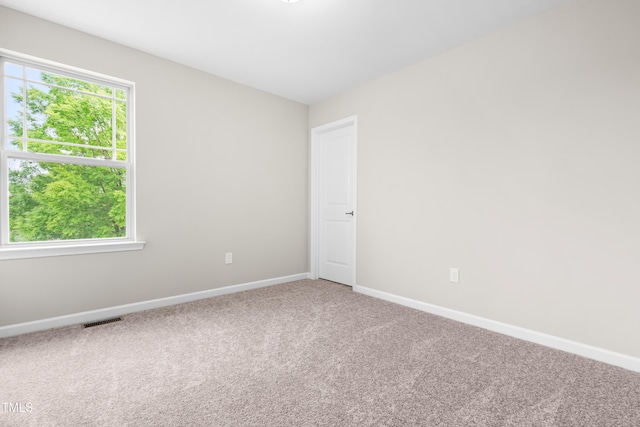 empty room featuring baseboards, carpet, and visible vents