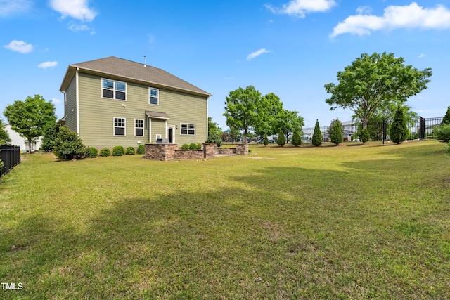 back of house featuring fence and a yard