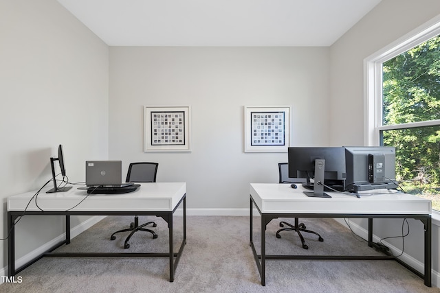 office featuring baseboards and light carpet