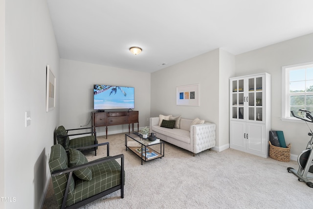carpeted living room featuring baseboards