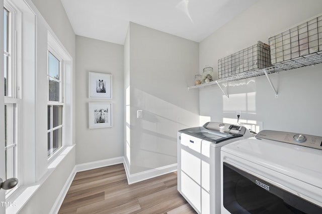 laundry room featuring washer and dryer, laundry area, baseboards, and light wood-style floors