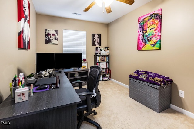 carpeted office space with a ceiling fan and baseboards
