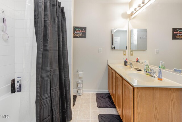 full bathroom featuring tile patterned flooring, a shower with curtain, double vanity, and baseboards