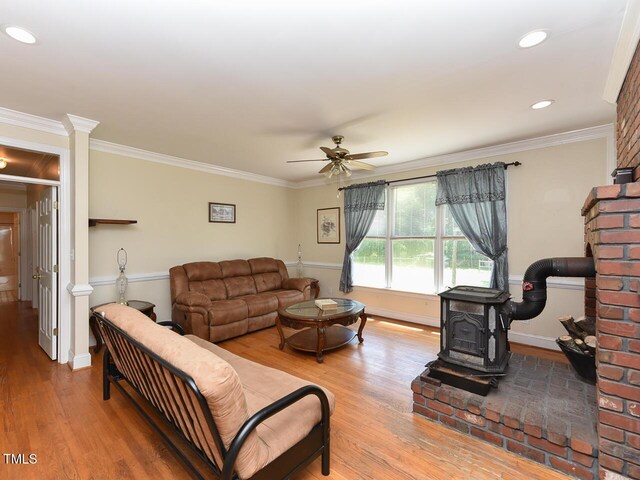 2371 NC-210, Smithfield, NC 27577 - living room with a wood stove, wood finished floors, a ceiling fan, crown molding, and baseboards