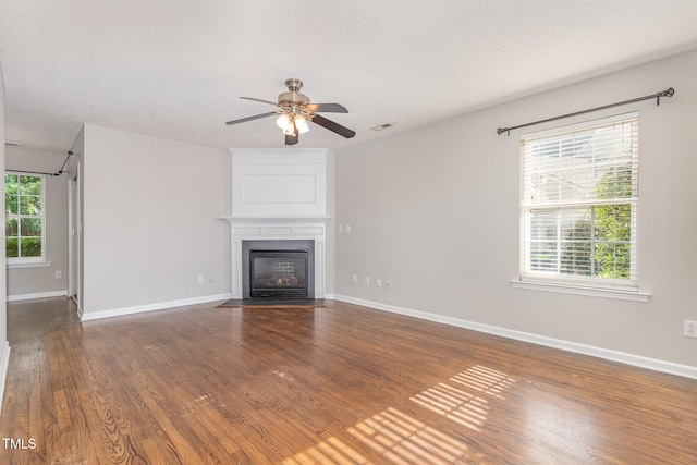 203 Downing Bluff Dr, Morrisville, NC 27560 - unfurnished living room with baseboards, a textured ceiling, ceiling fan, and a fireplace
