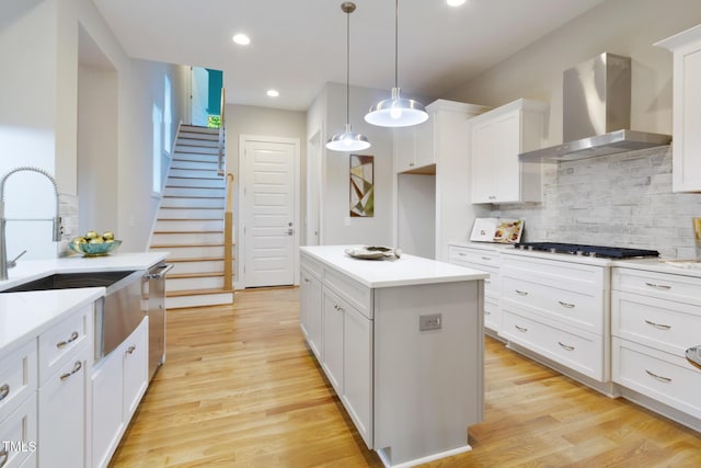 211 Page St, Morrisville, NC 27560 - kitchen featuring wall chimney range hood, white cabinetry, decorative backsplash, and light wood finished floors