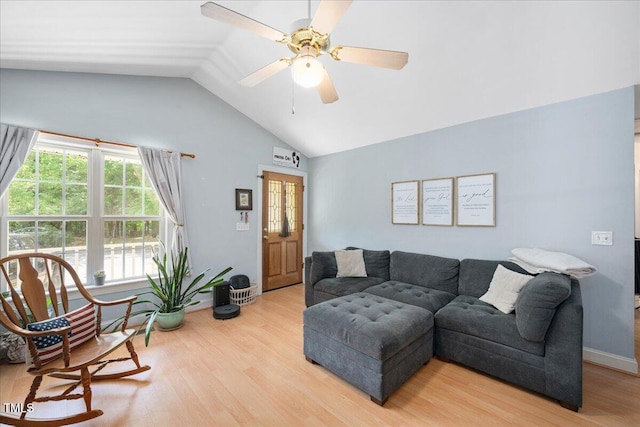 living room featuring a ceiling fan, vaulted ceiling, and light wood finished floors