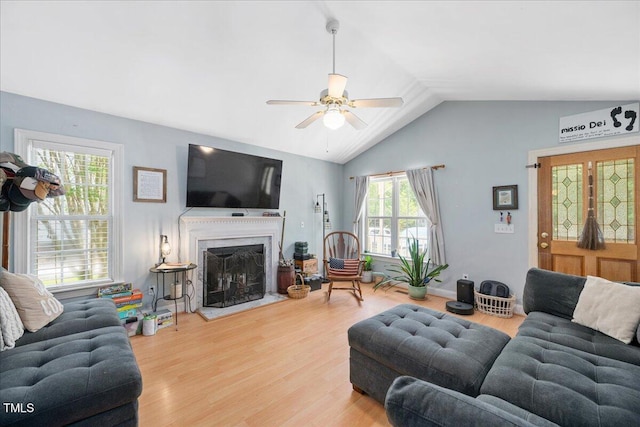 living area with ceiling fan, wood finished floors, lofted ceiling, and a high end fireplace
